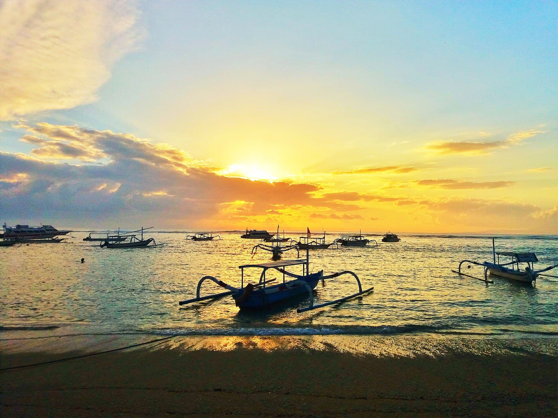Lever de soleil sur des bateaux dans le lagon de Sanur