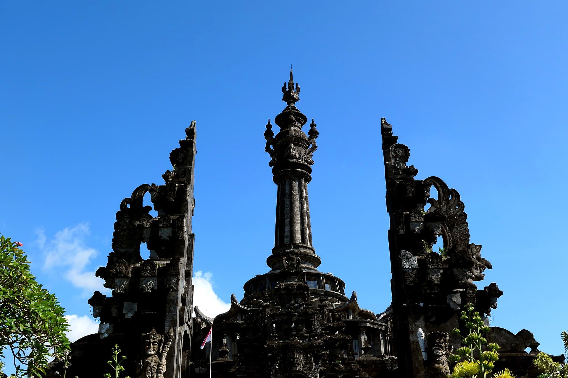Le monument Bajra Sandhi encadré par un portail fendu sculpté sous le ciel bleu de Denpasar